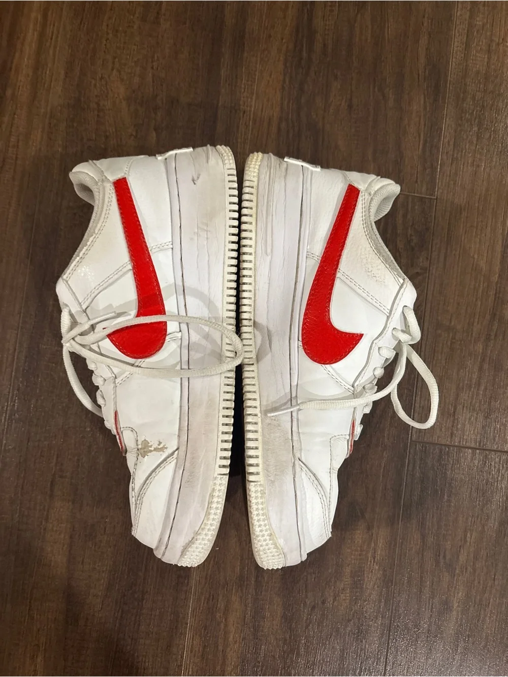 Nike Air Force 1 white sneakers with red Nike swoosh